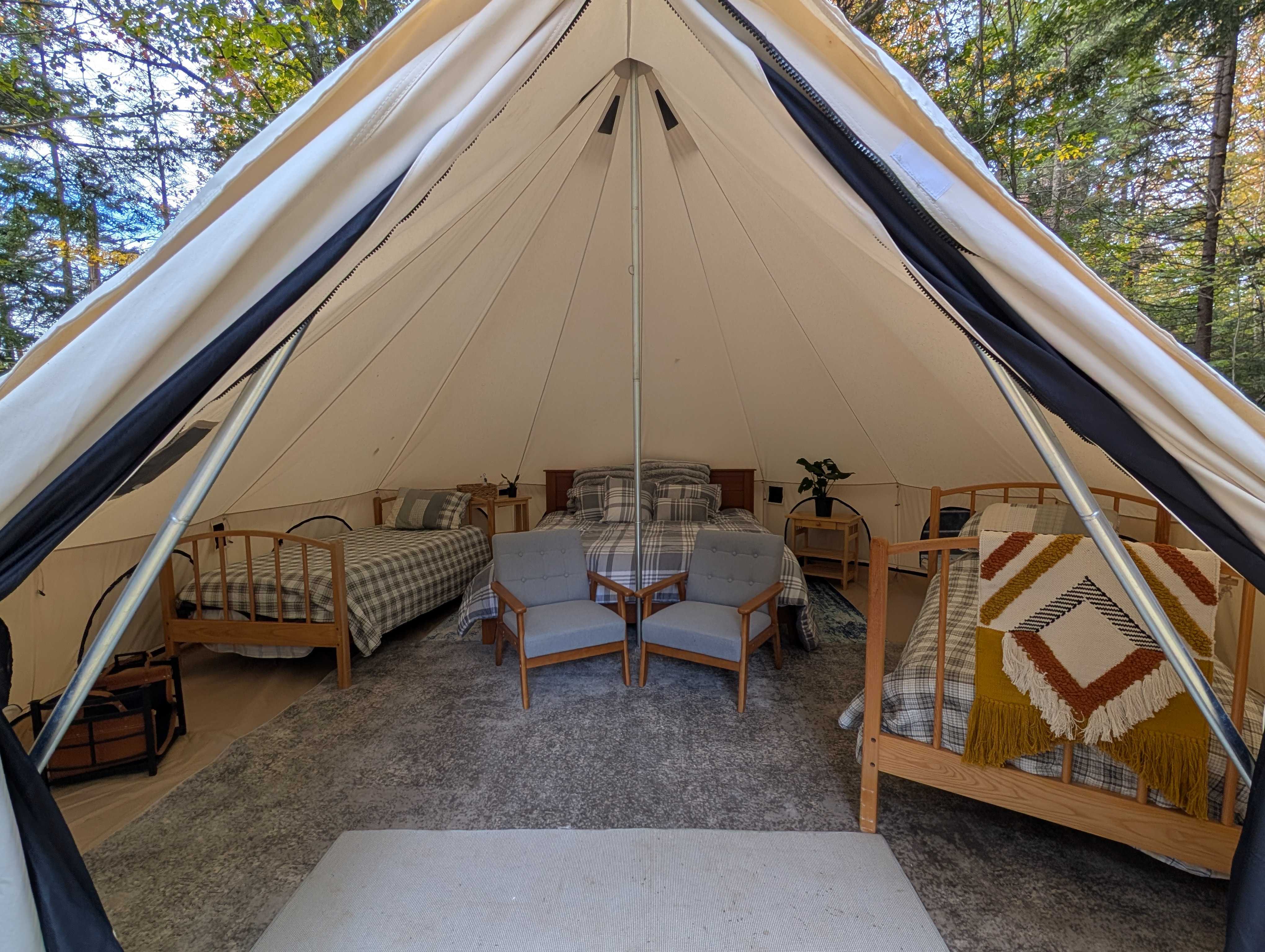 Inside view of bell tent offering cozy seating and beds