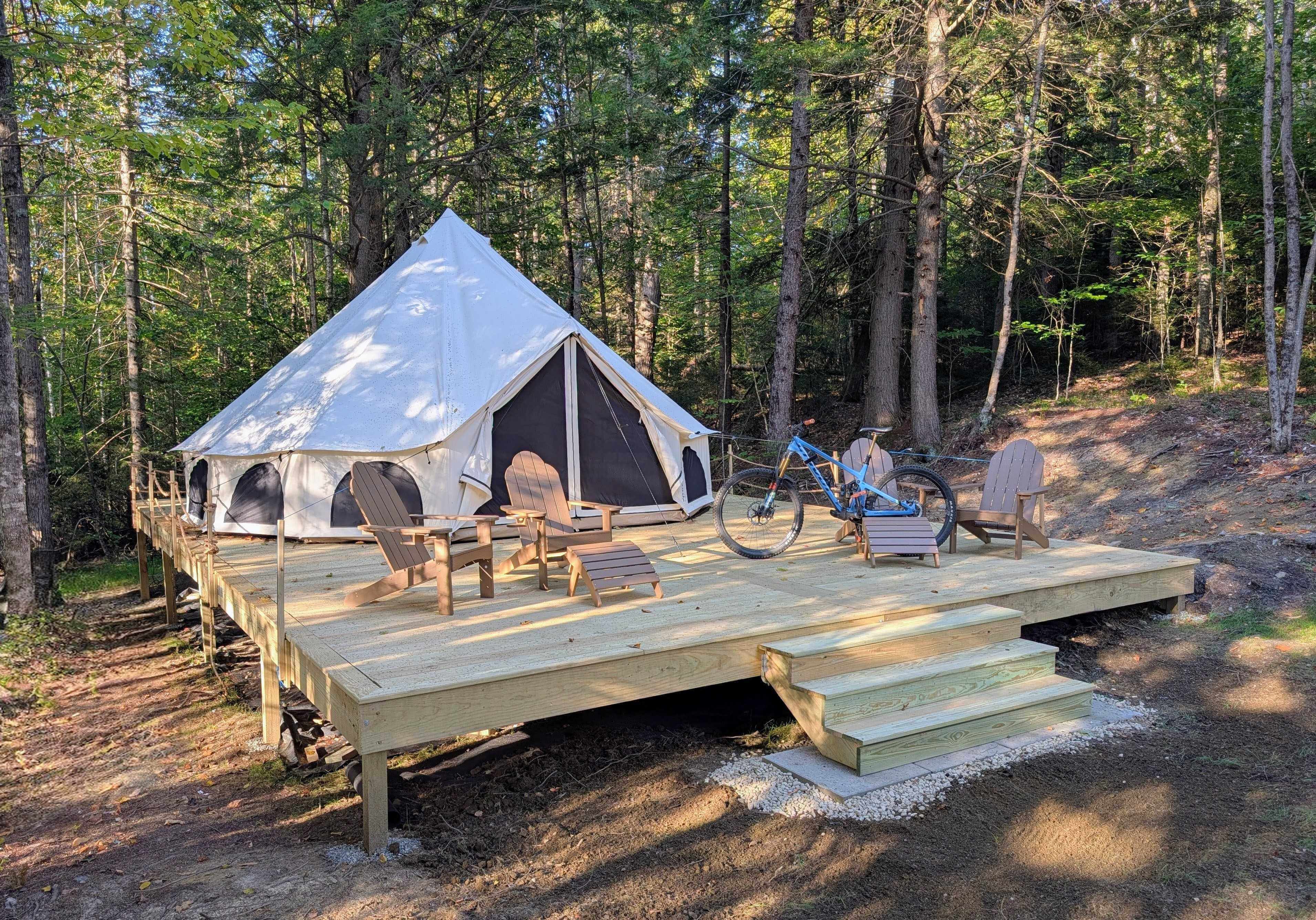 Bell tent platform in evening light surrounded by Vermont forest